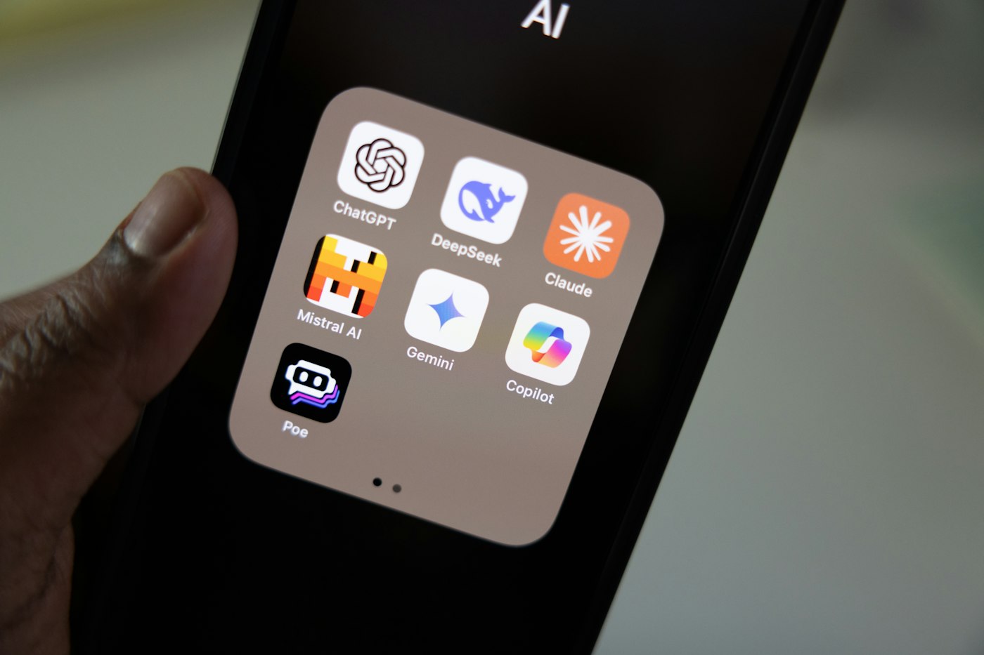Téléphone affichant les applications Claude, ChatGPT et Gemini